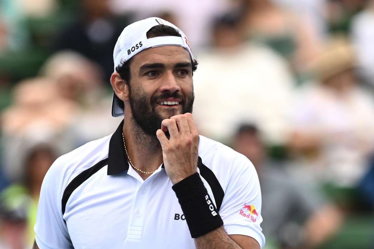 Matteo Berrettini con il berretto in testa al contrario si tocca le labbra