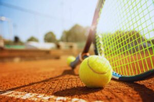Pallina e racchetta da tennis su campo da tennis